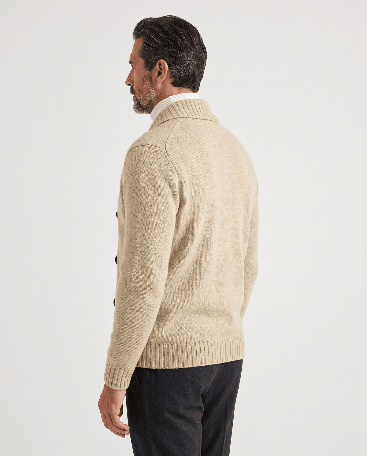 Back view of apricot double-breasted cardigan worn with dark trousers
