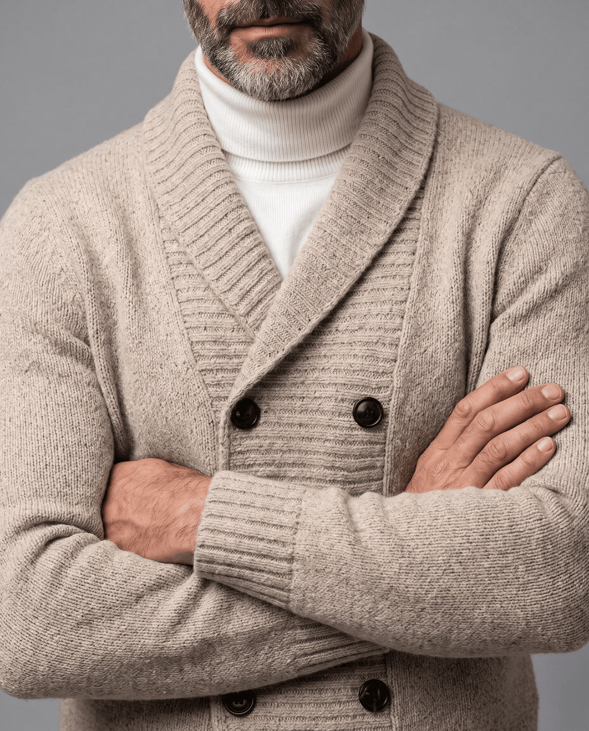 Beige double-breasted cardigan with arms crossed showing buttons and ribbed cuffs