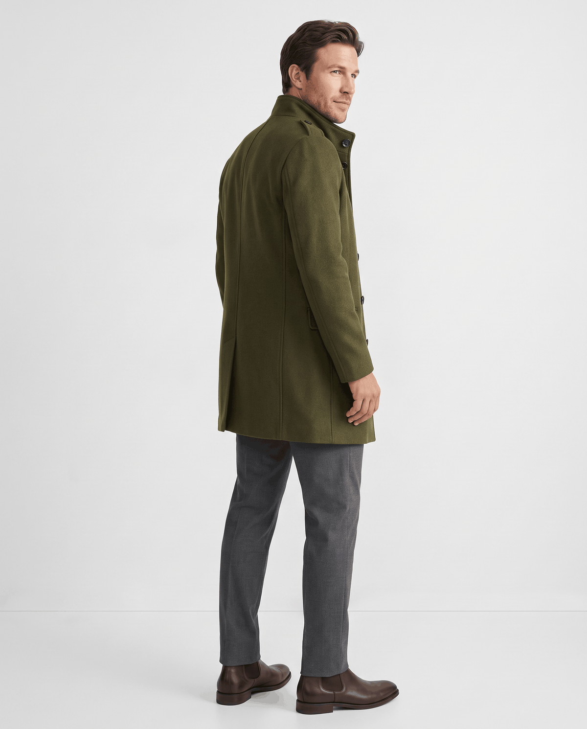 Back view of the army green overcoat worn with gray trousers and brown boots