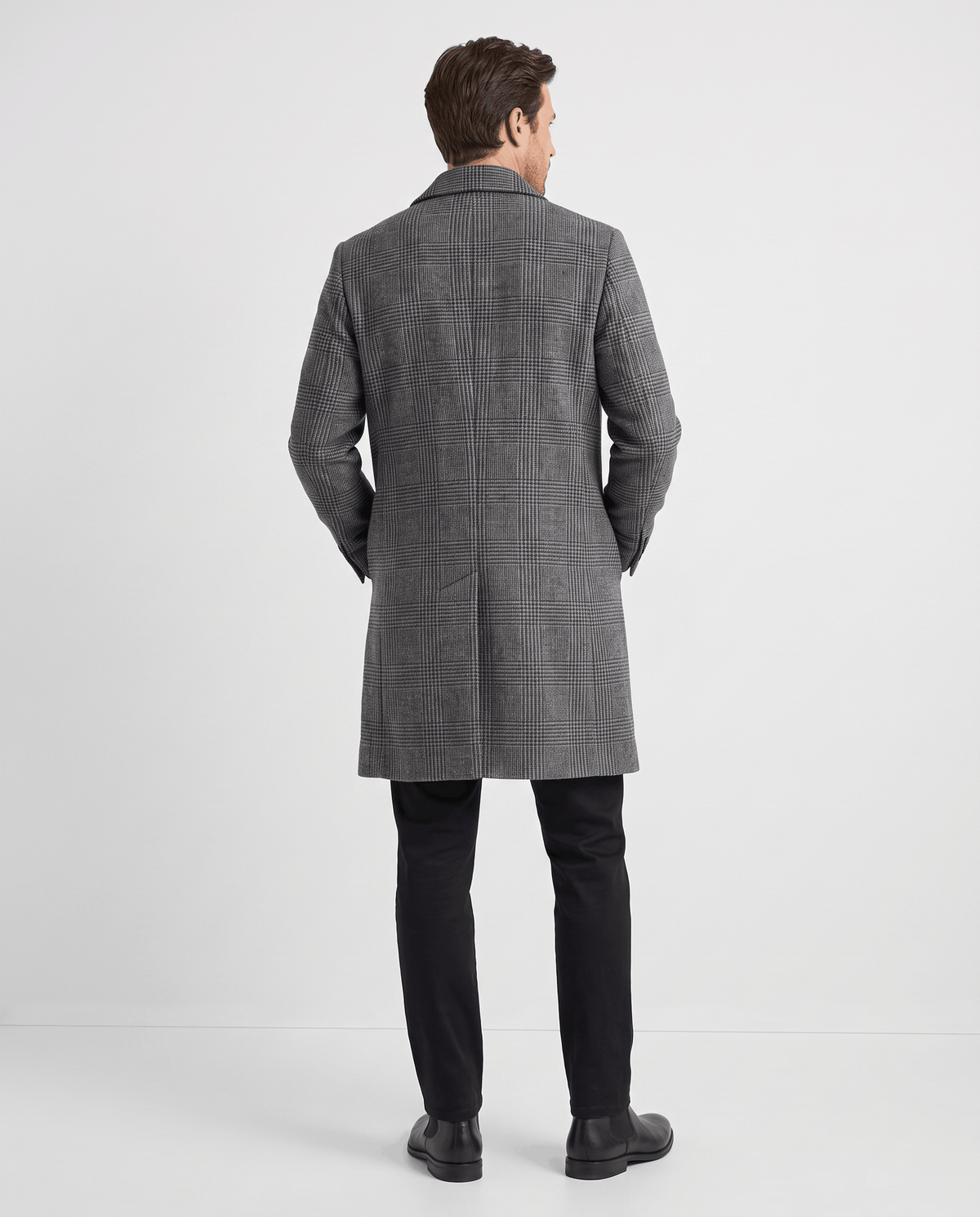 Back view of the long gray overcoat worn with dark trousers and shoes