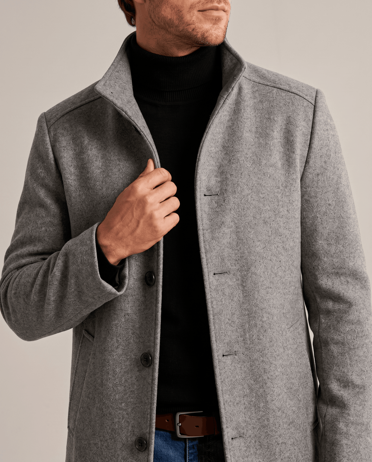Gray overcoat with a turned-up stand collar and one hand at the button placket