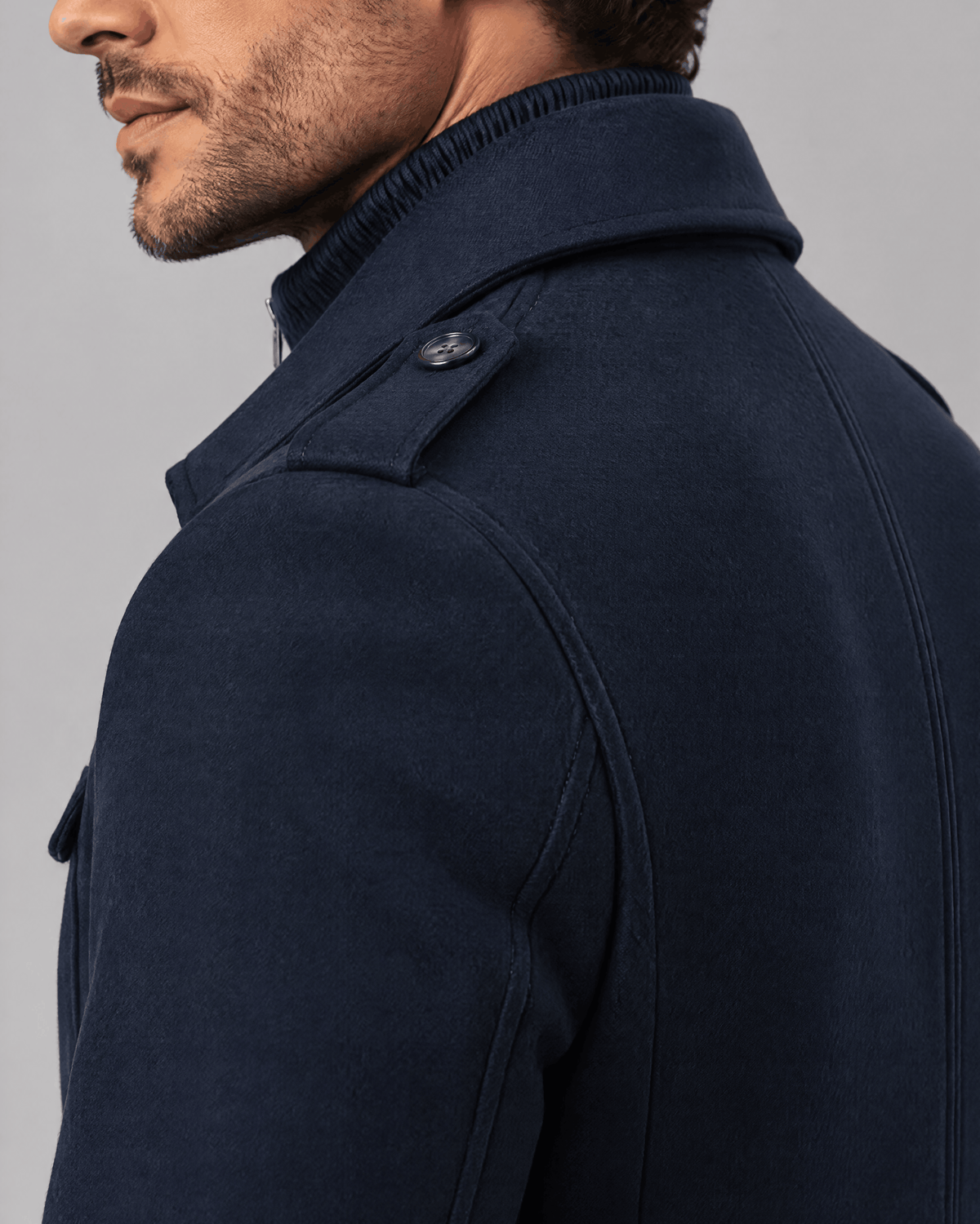Navy coat shoulder and collar close-up showing the epaulette and fabric texture