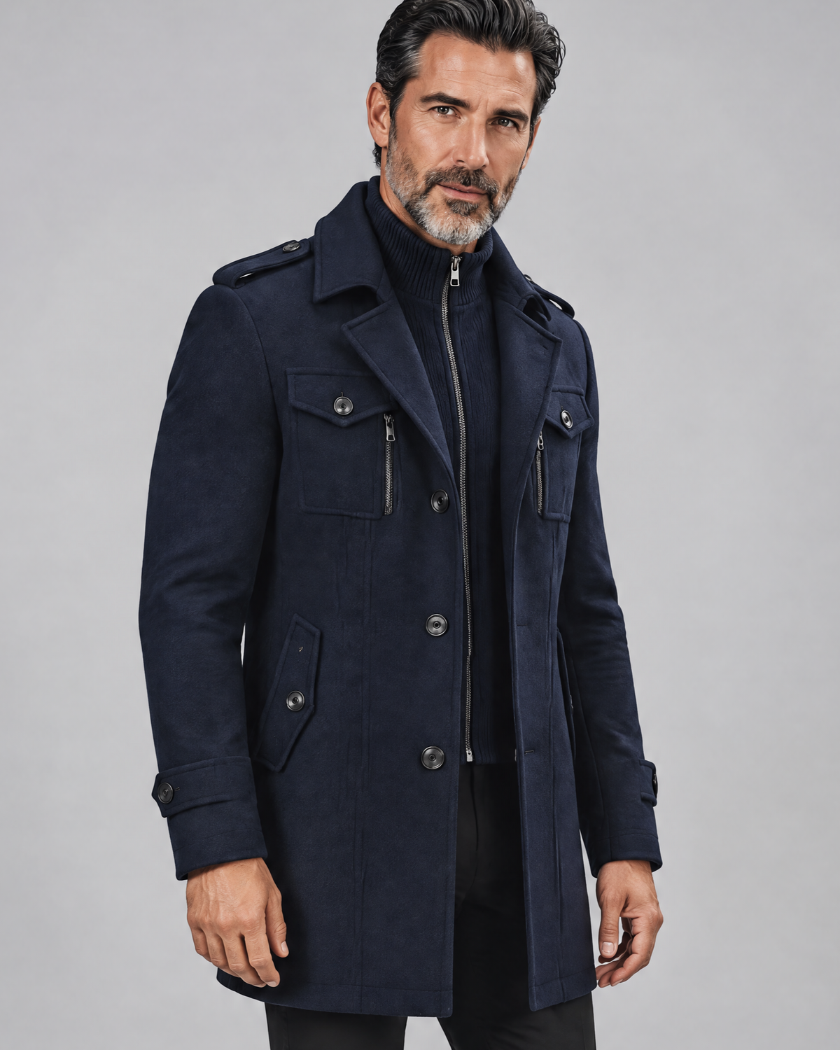 Navy military-style coat with a dark knit bib, epaulettes and a closed front, shown at an angle