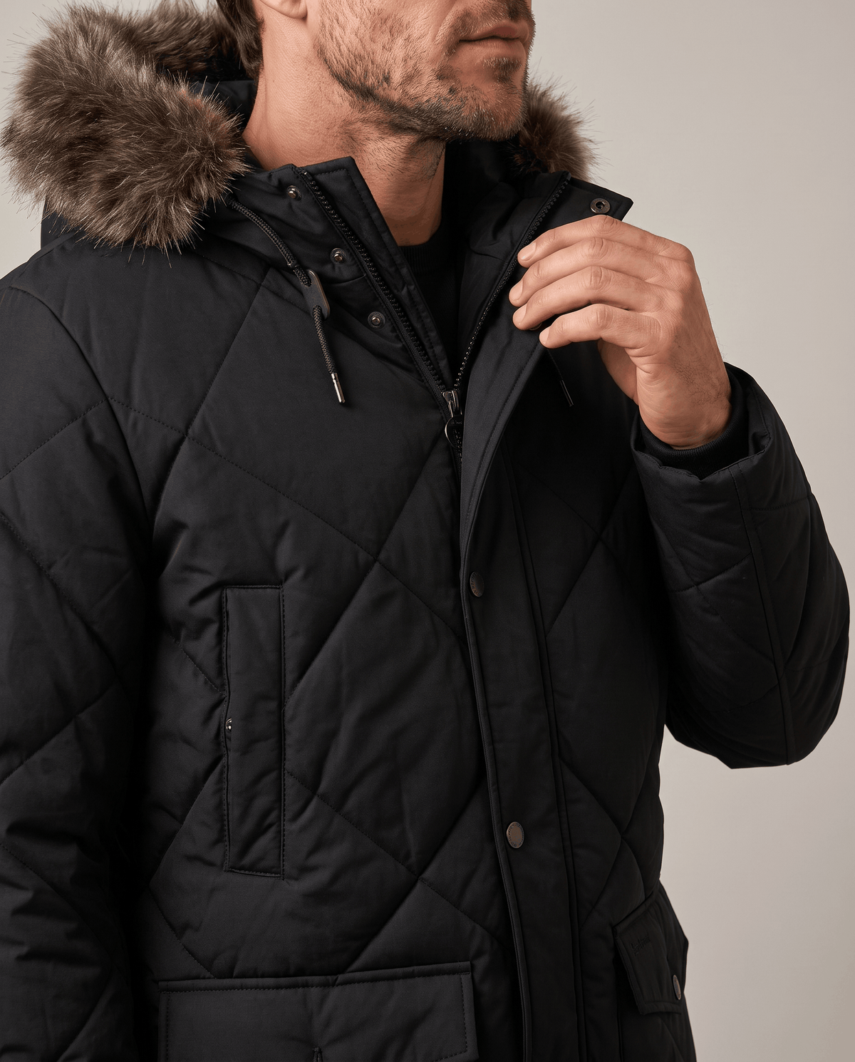 Men's black quilted long parka, front close-up showing the collar