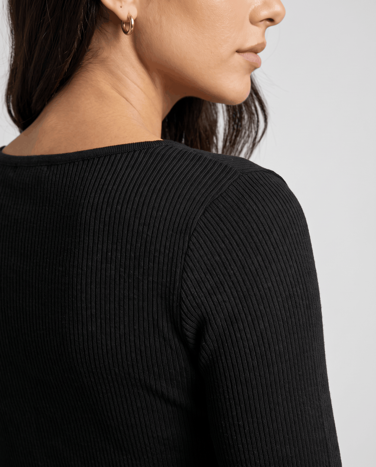 Close-up of black ribbed knit sleeve and shoulder from the side