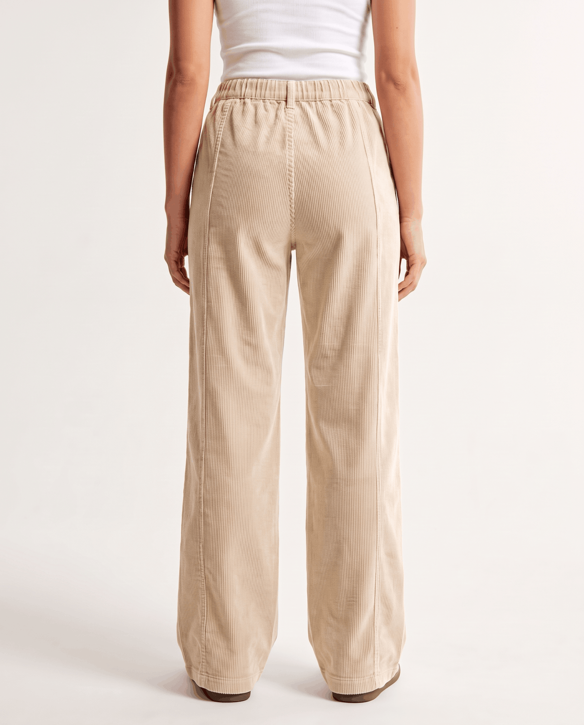 Back view of ivory corduroy pants showing the elastic back waistband and straight wide leg