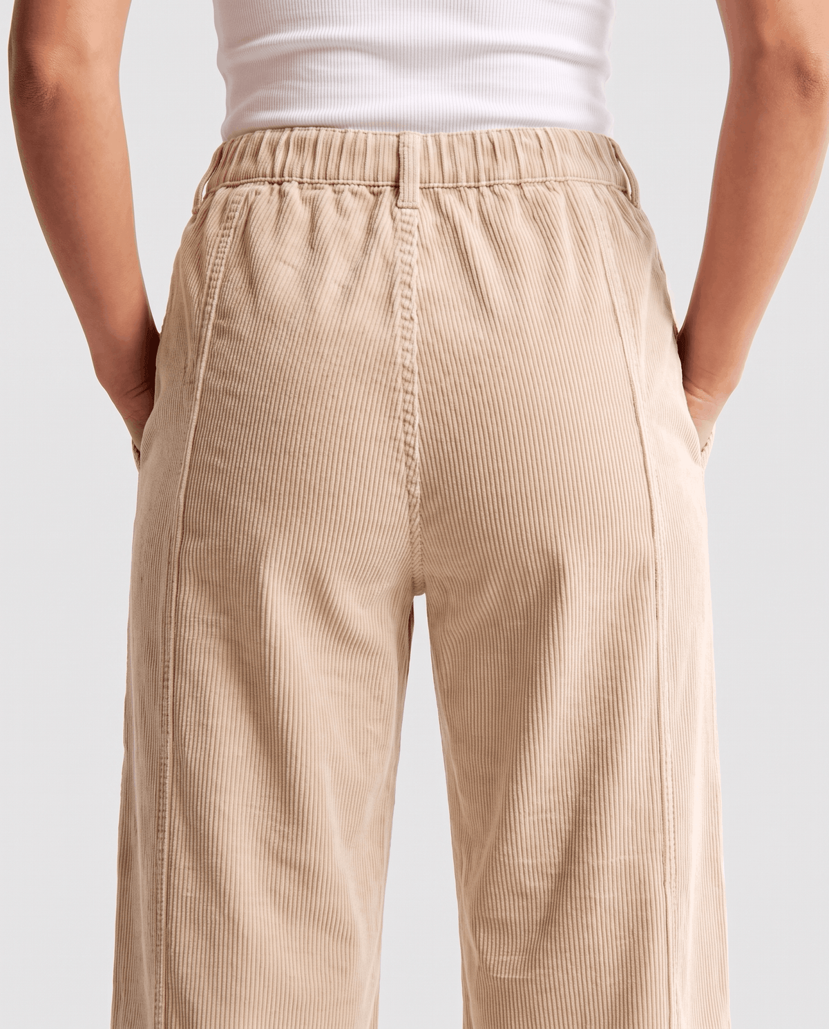 Back close-up of cream wide-rib fabric at the elastic waistband and hip
