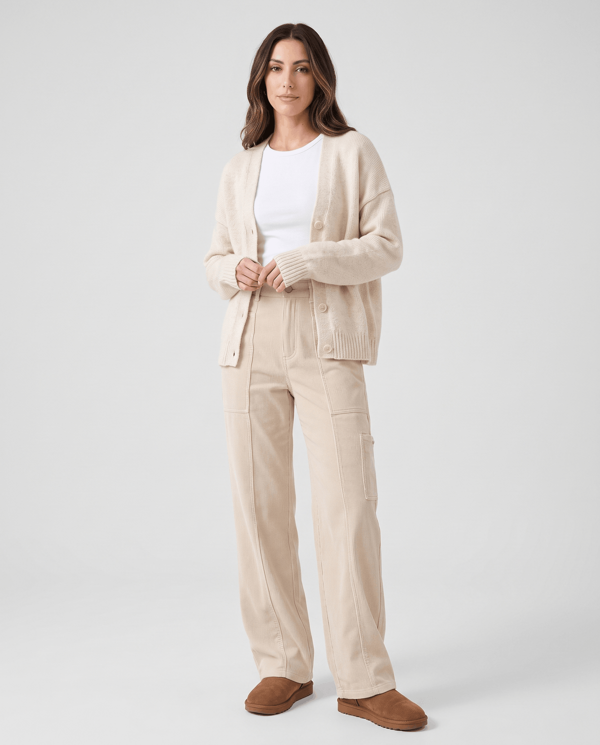 Model in cream ribbed trousers styled with a matching cardigan and brown suede shoes