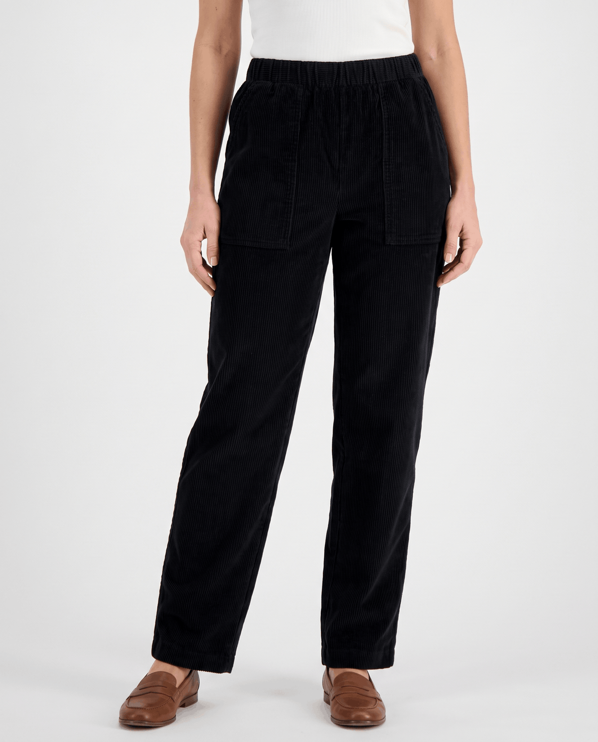 Front view of black high-rise ribbed pants with patch pockets and tan loafers