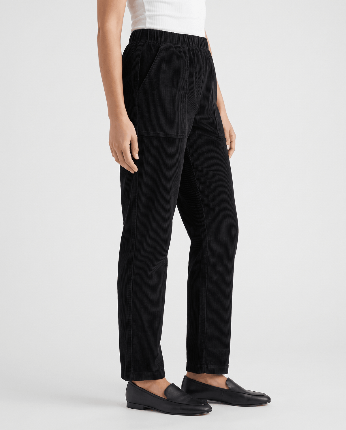 Side profile of black pull-on trousers showing the straight leg and black loafers