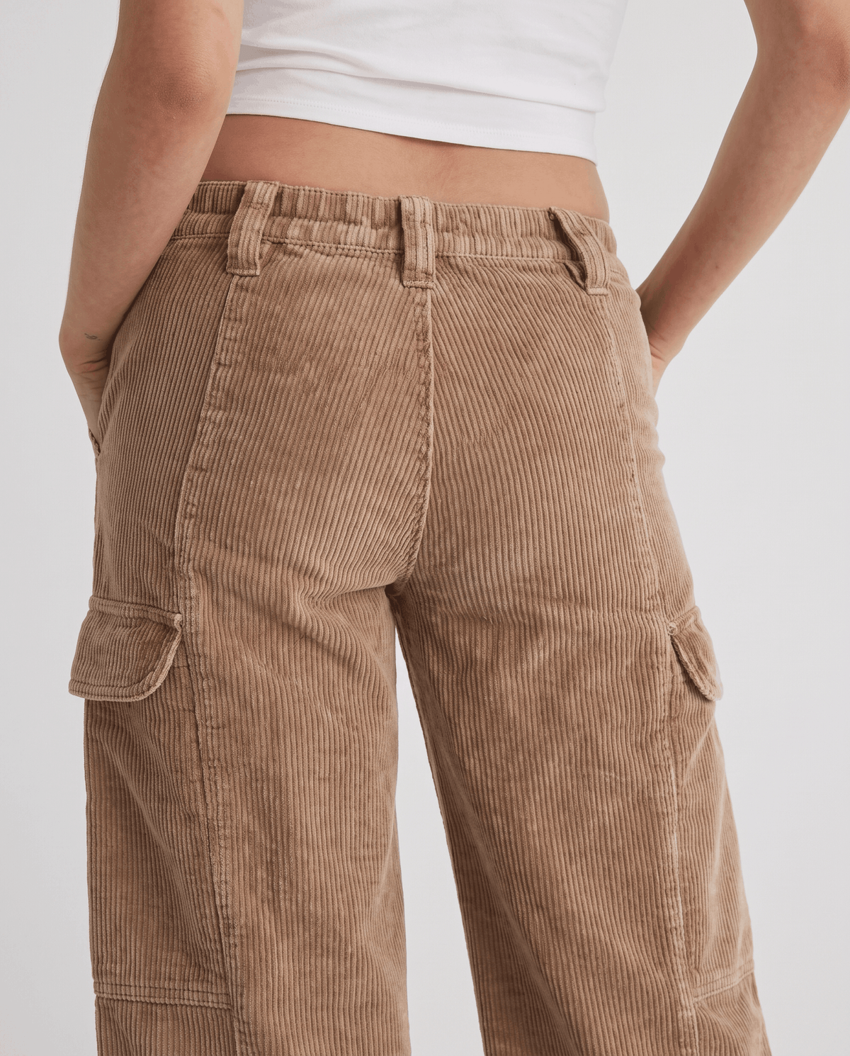 Back close-up of washed tan ribbed fabric with belt loops and side cargo pockets