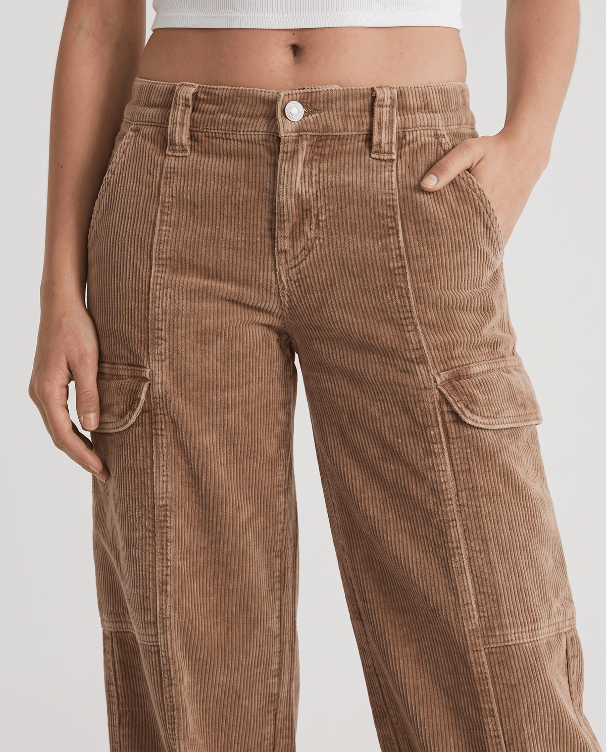 Close-up of the zip fly, belt loops, front seams and flap cargo pockets on tan corduroy