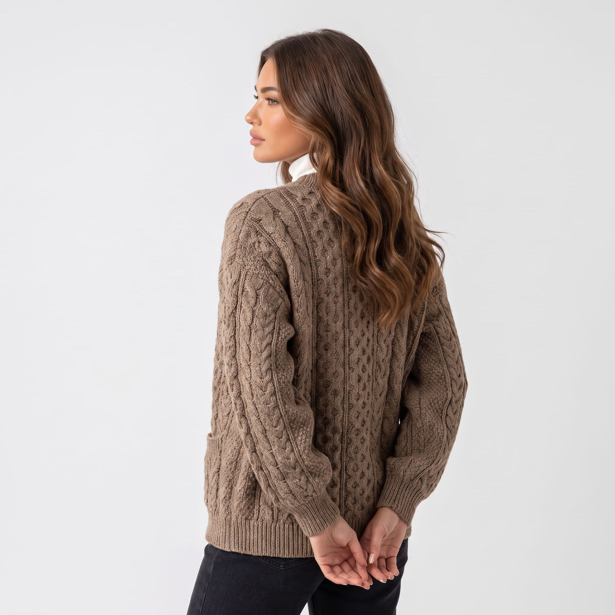 Back view of camel cable-knit cardigan worn with black trousers