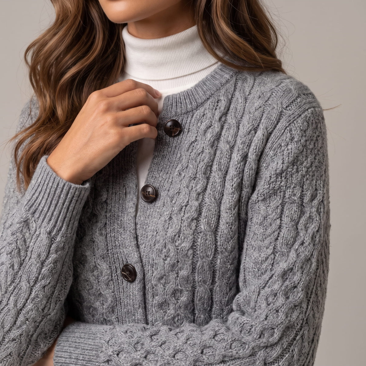 Gray cable-knit cardigan buttons and cable pattern shown in close view