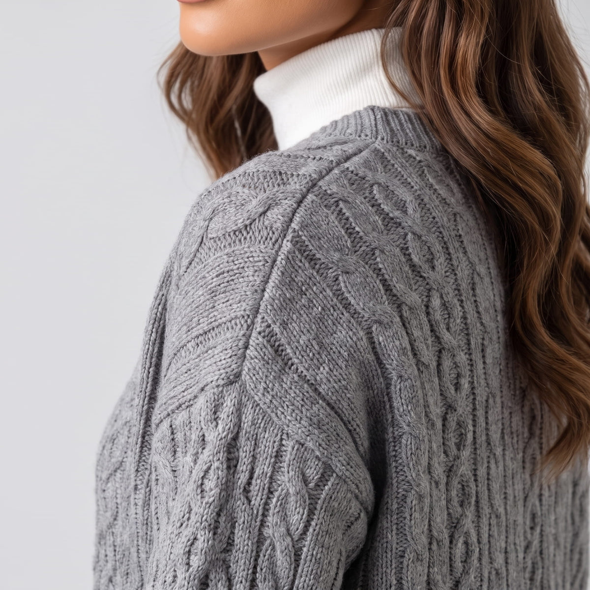 Close side view of gray cable-knit cardigan sleeve and shoulder