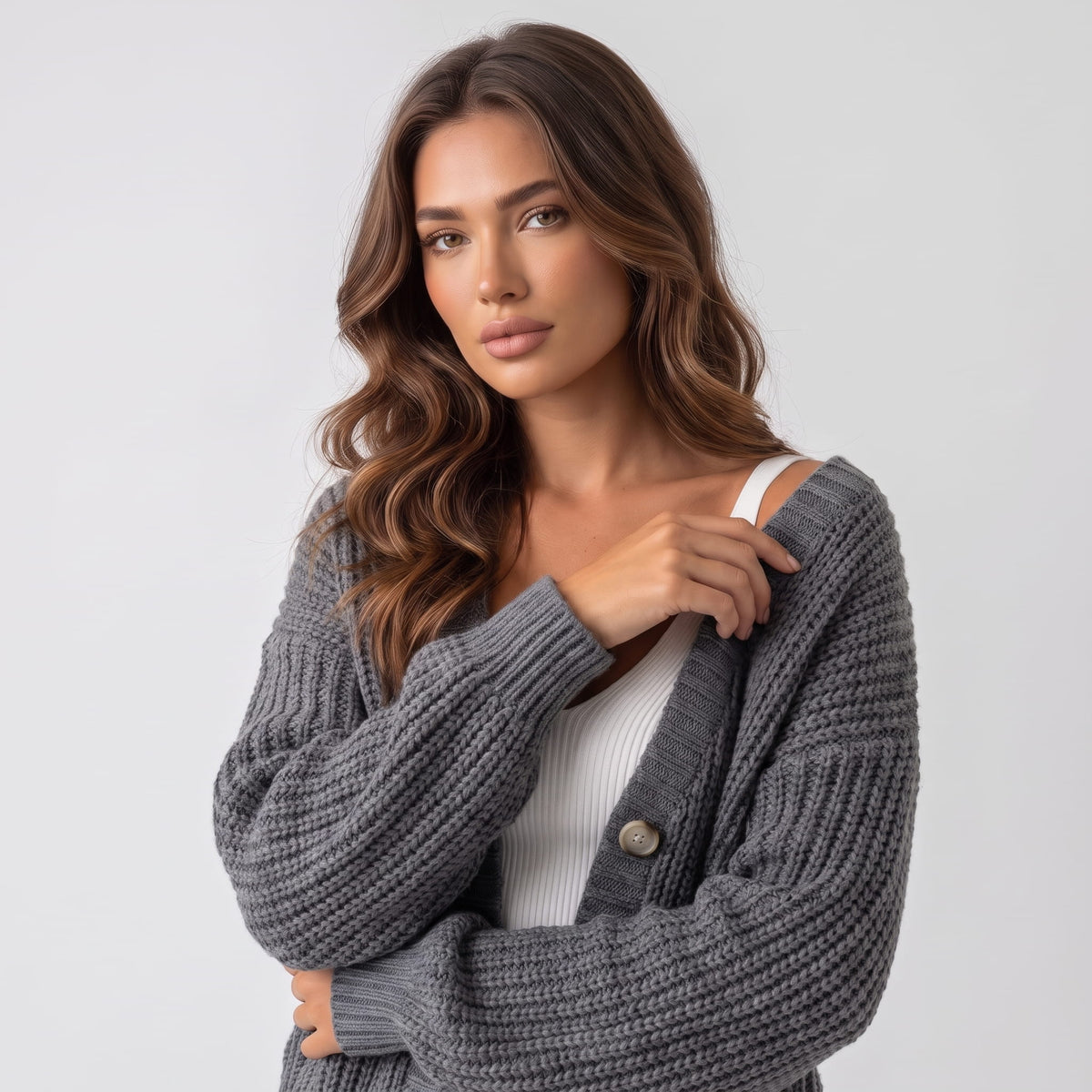 Gray chunky knit cardigan worn open showing V neckline and button placket