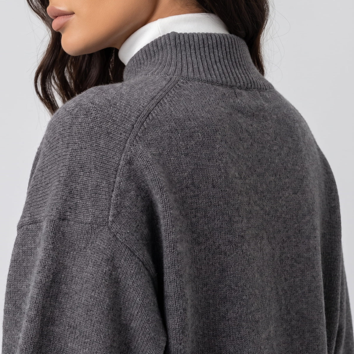 Side detail of dark gray knit with raglan seam and ribbed collar