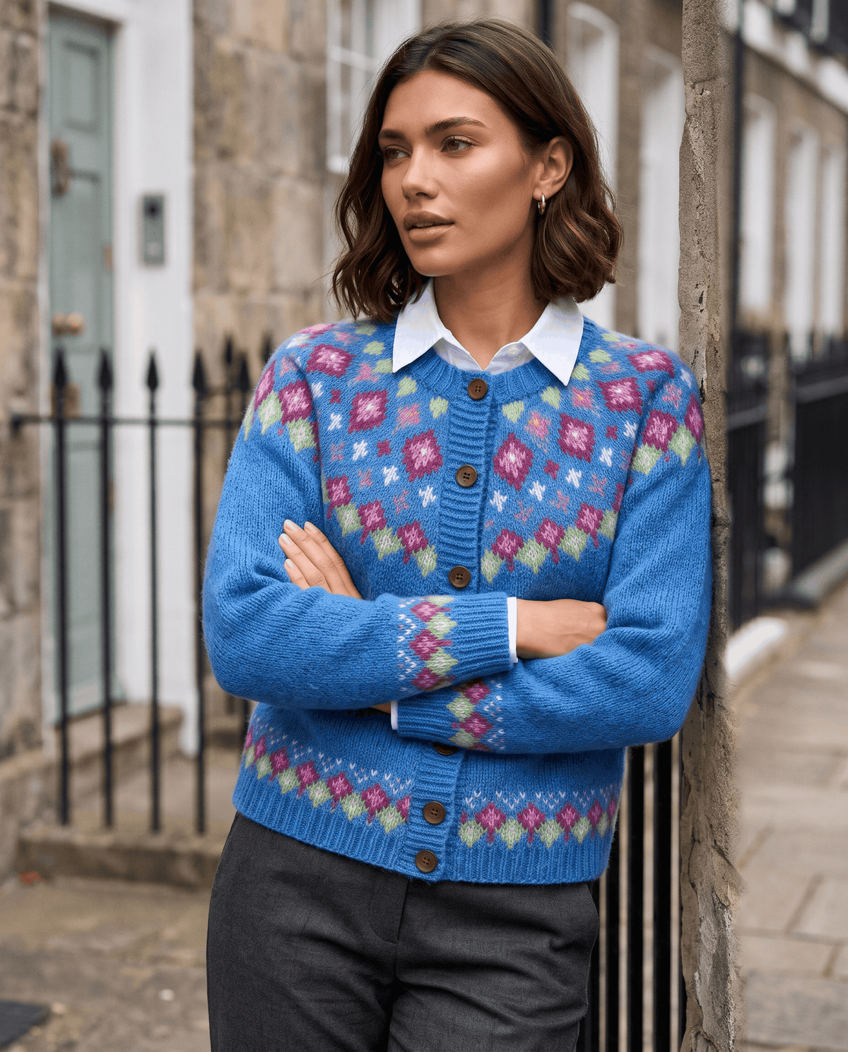 Blue Fair Isle cardigan styled with a collared shirt on a city street