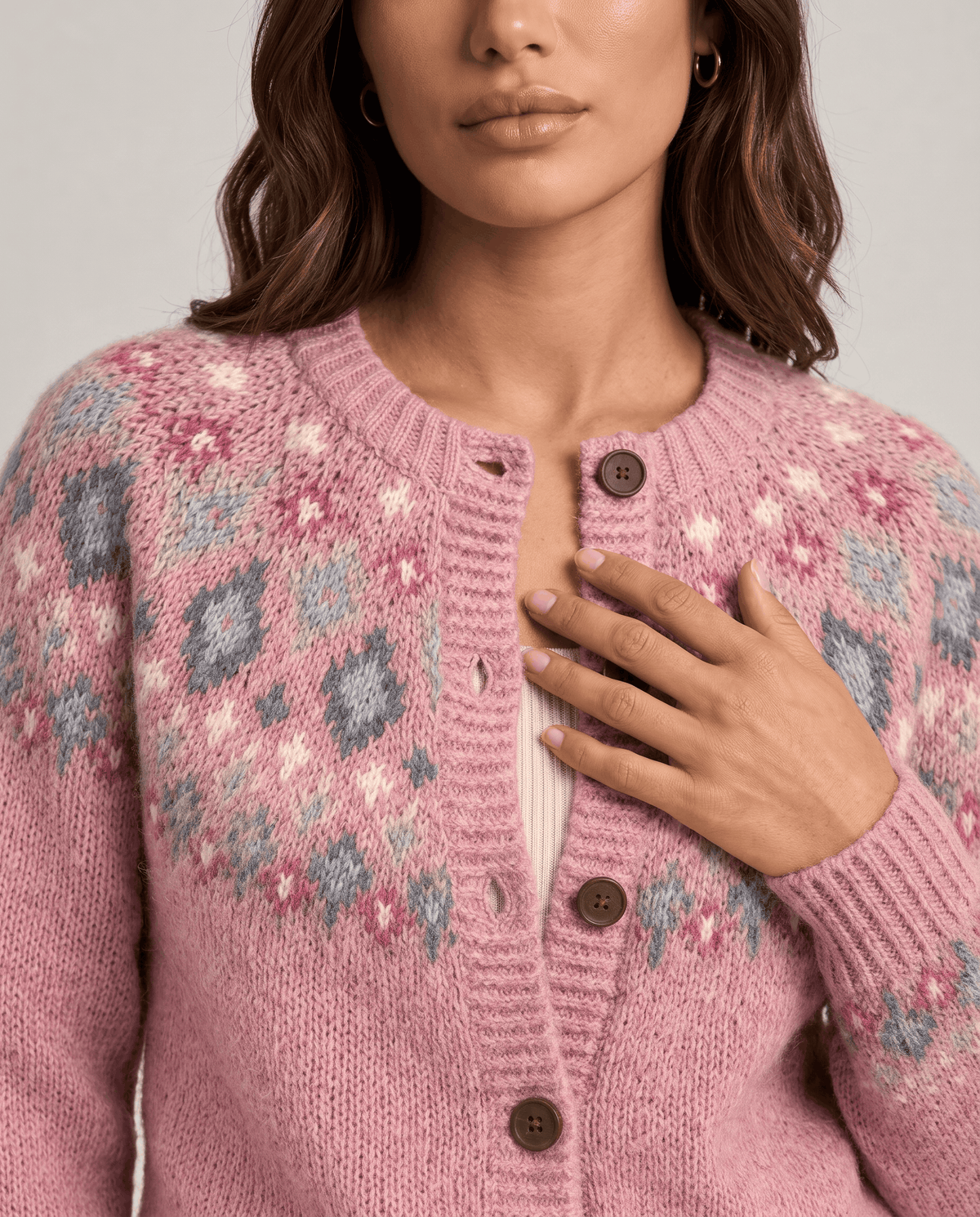 Close-up of pink Fair Isle yoke pattern with diamonds, flowers and brown buttons