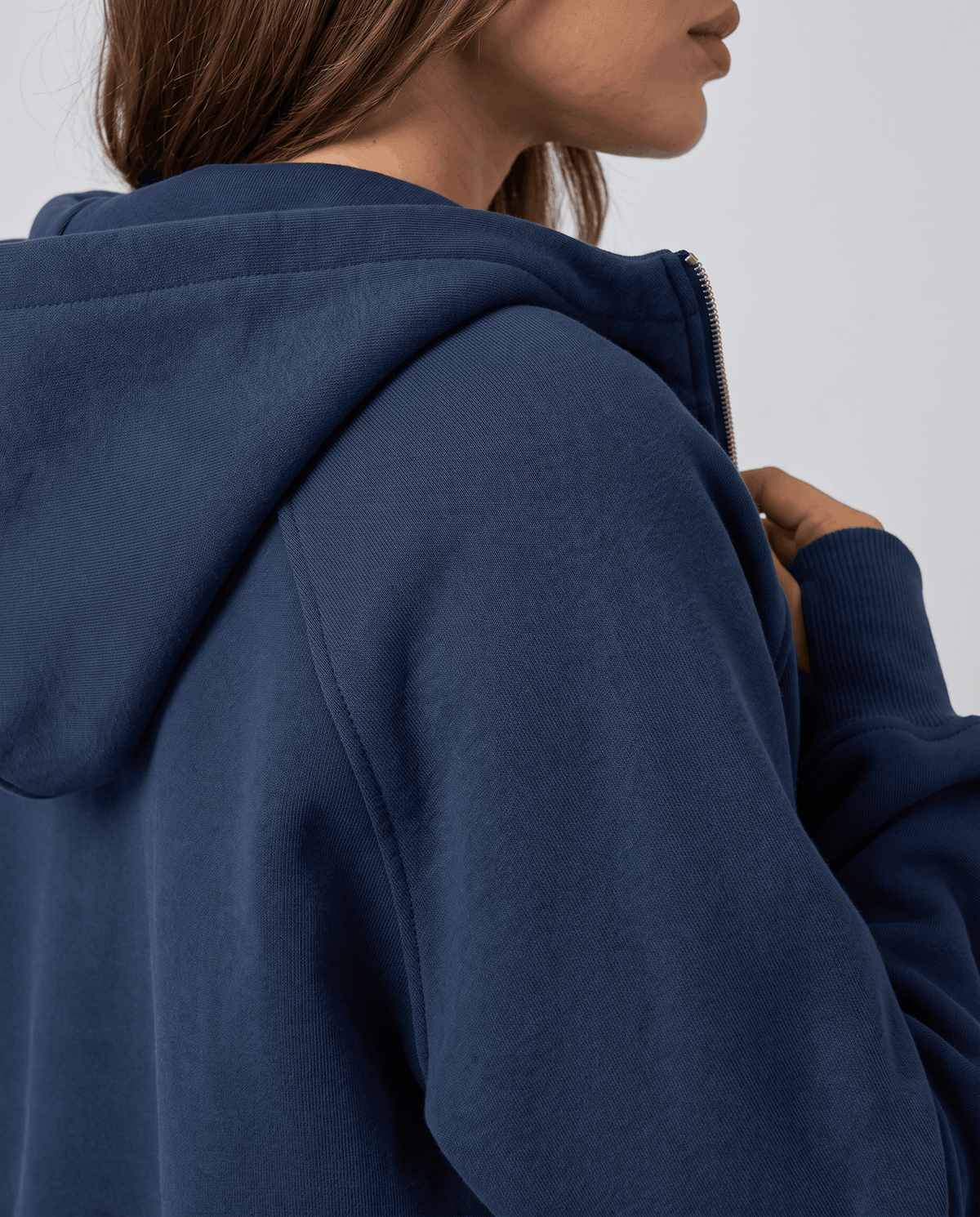 Close-up of the navy hood and soft drop shoulder seam from the side