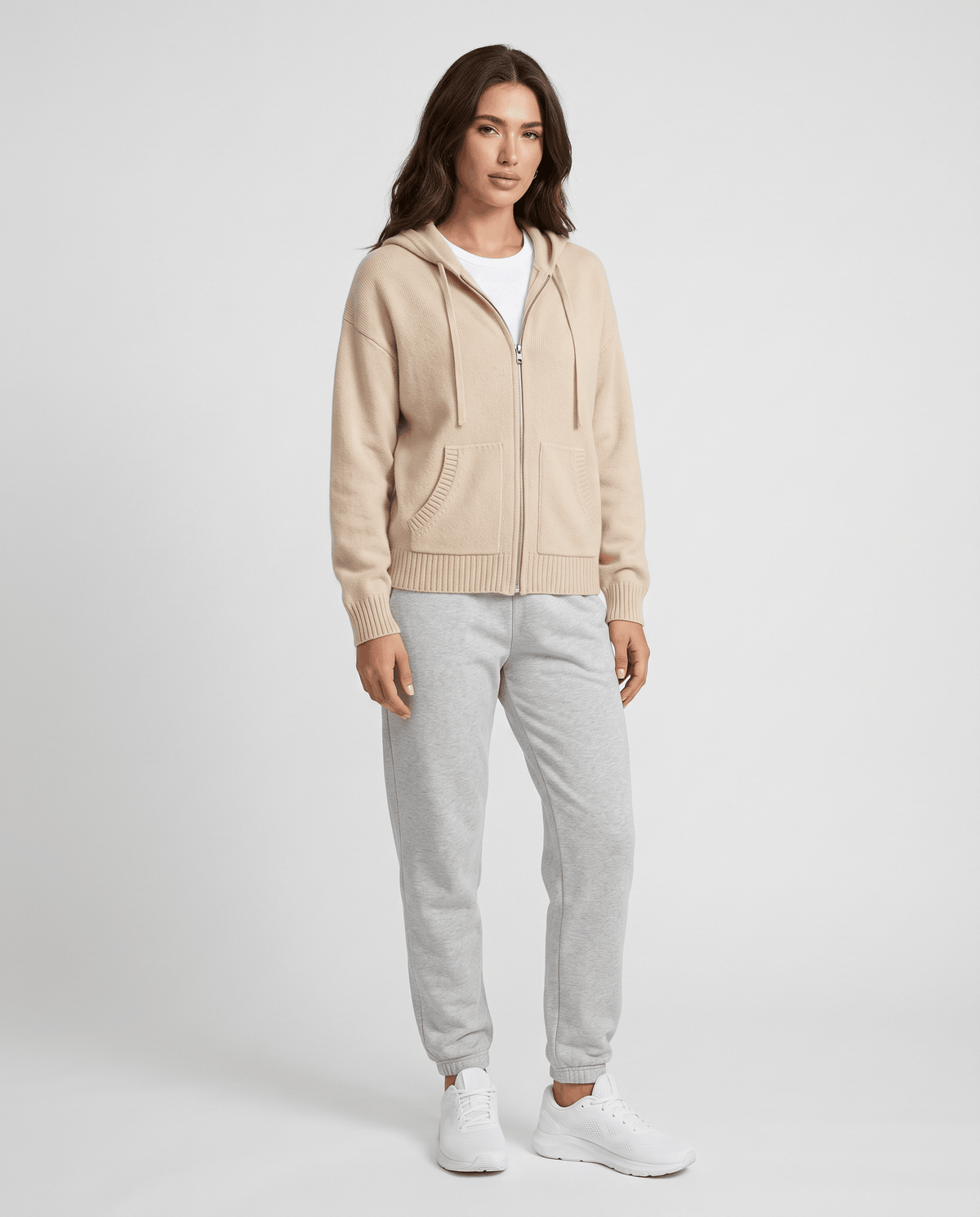 Full-length beige hooded cardigan styled with light gray joggers and white sneakers