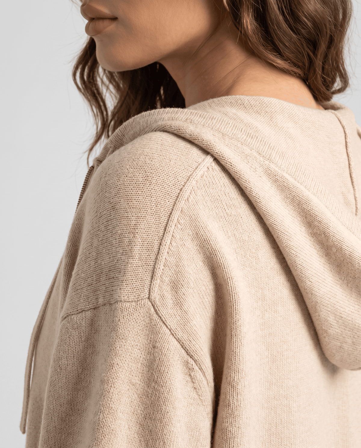 Side close-up of beige cardigan hood showing the soft knit texture