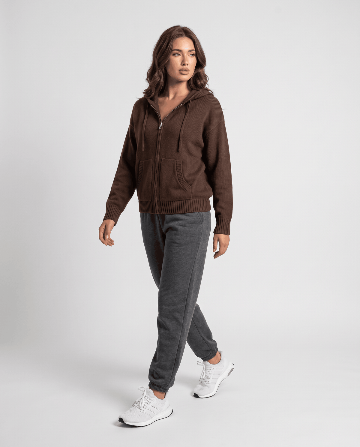 Full-length dark brown hooded cardigan styled with gray pants and white sneakers