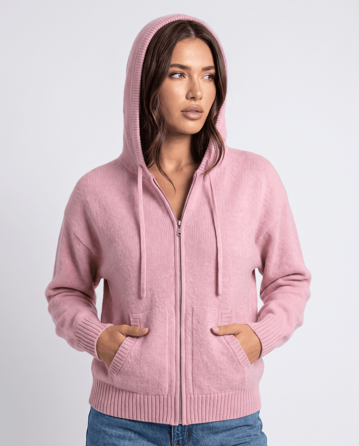 Light pink hooded cardigan with the hood up, zip closed and hands in the pockets