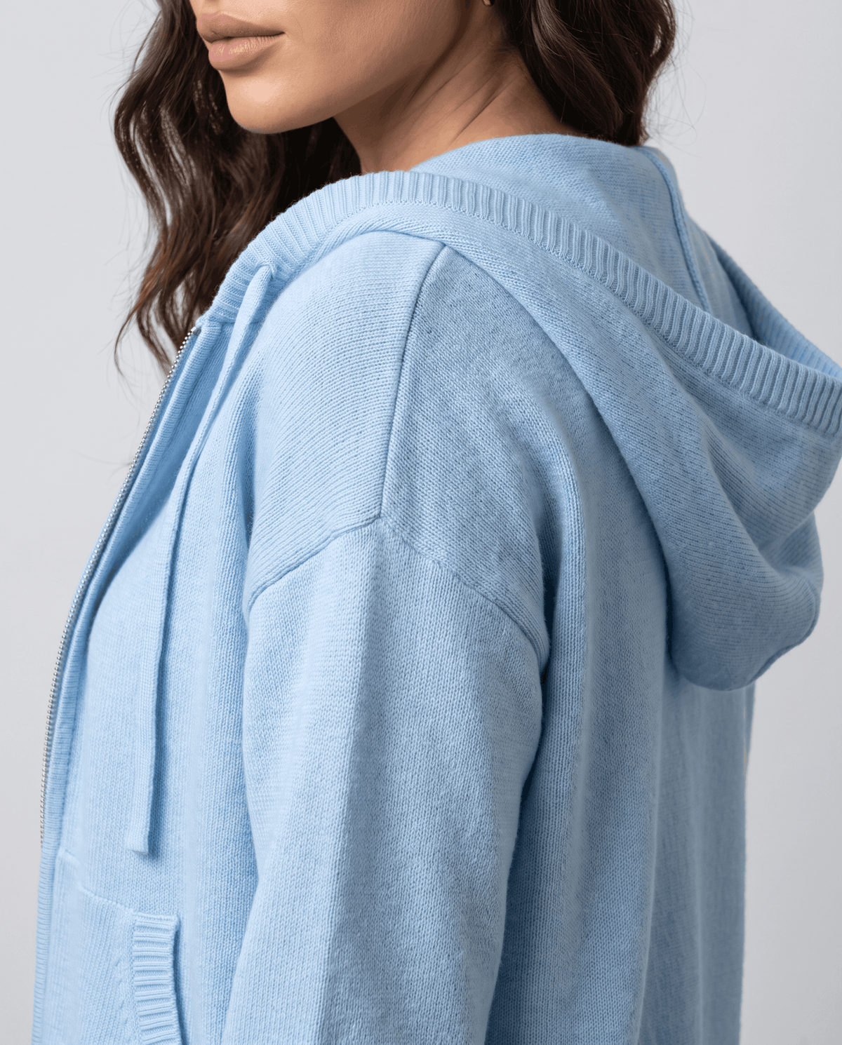 Side close-up of sky blue cardigan hood showing the soft knit texture and shoulder seam