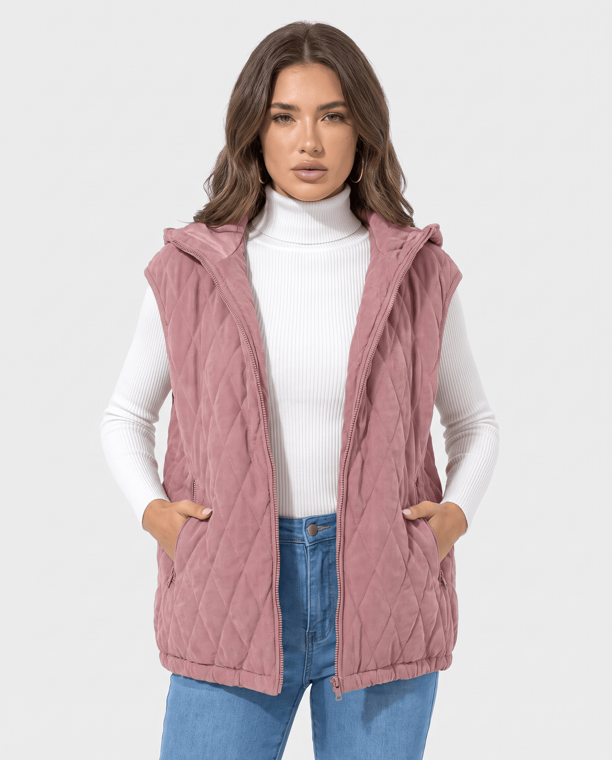 Pink hooded quilted vest with hands in front pockets, worn with jeans