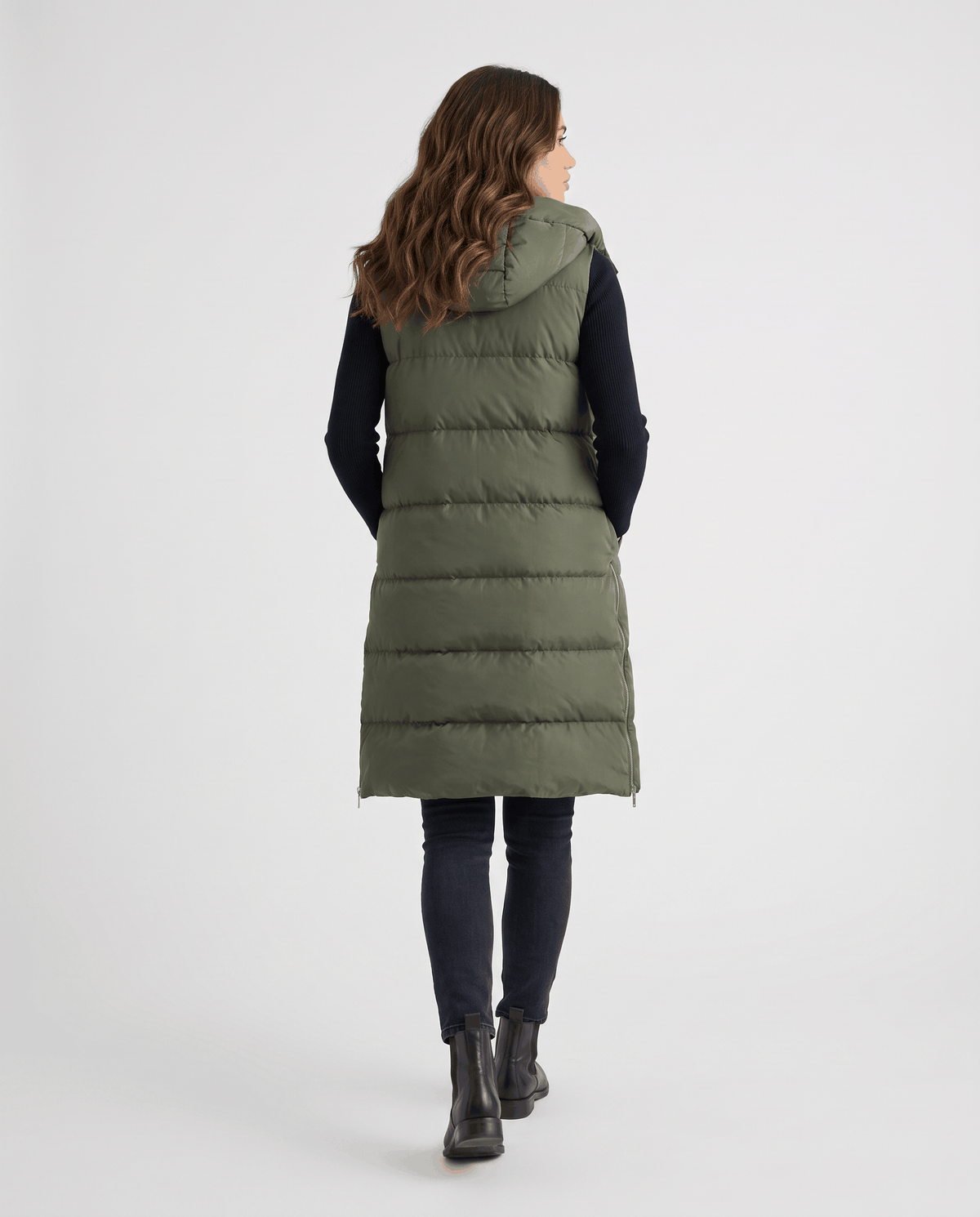Back view of army green knee-length hooded quilted vest with boots