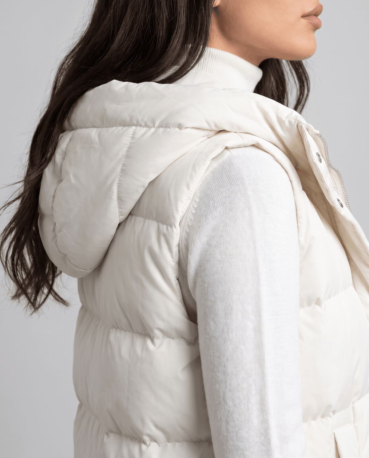 Side view of cream quilted vest hood and sleeveless armhole