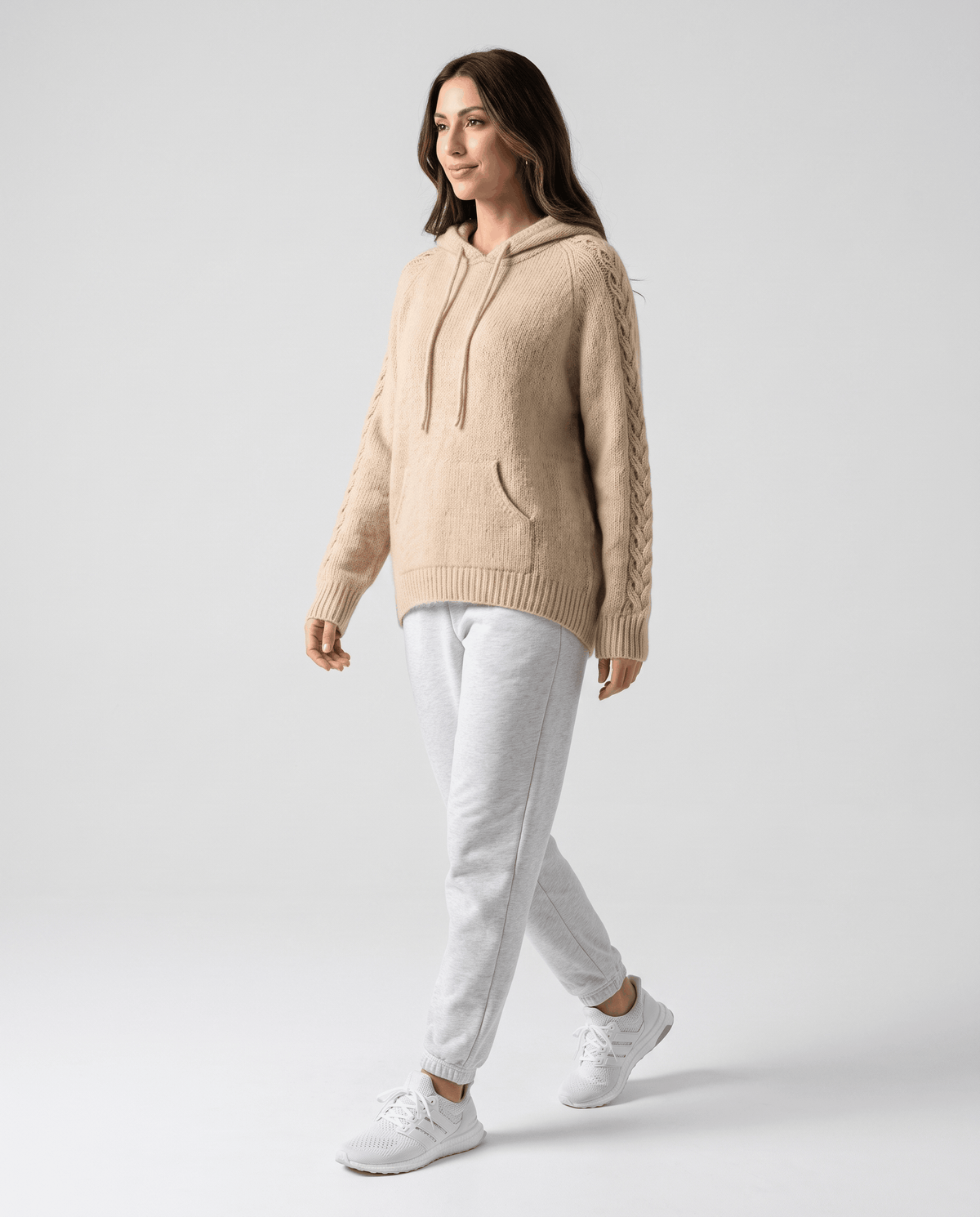 Full-length walking look pairing the light brown hooded sweater with white joggers and sneakers