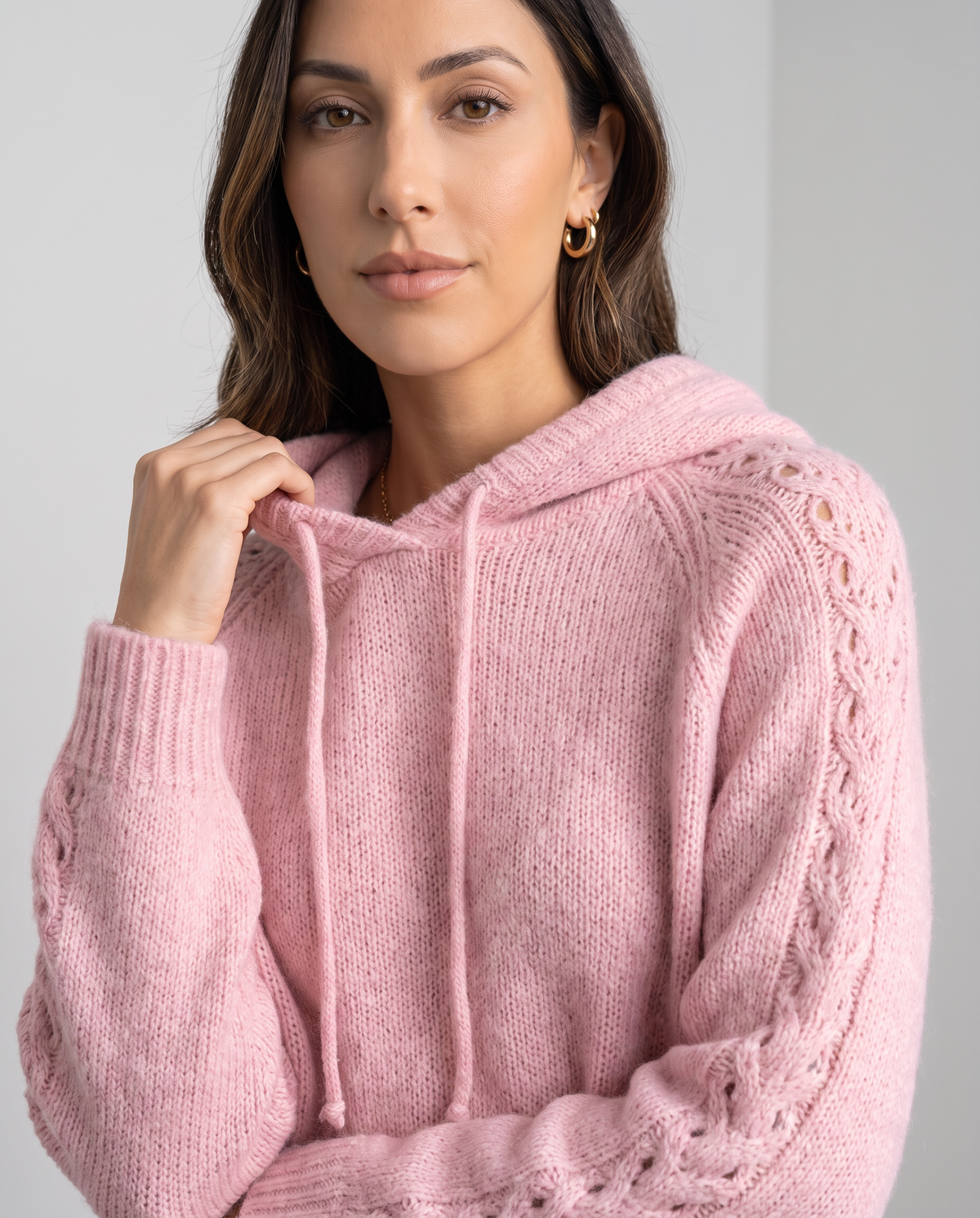 Close-up of the pink hood, drawstring and open-stitch knit on the sleeve