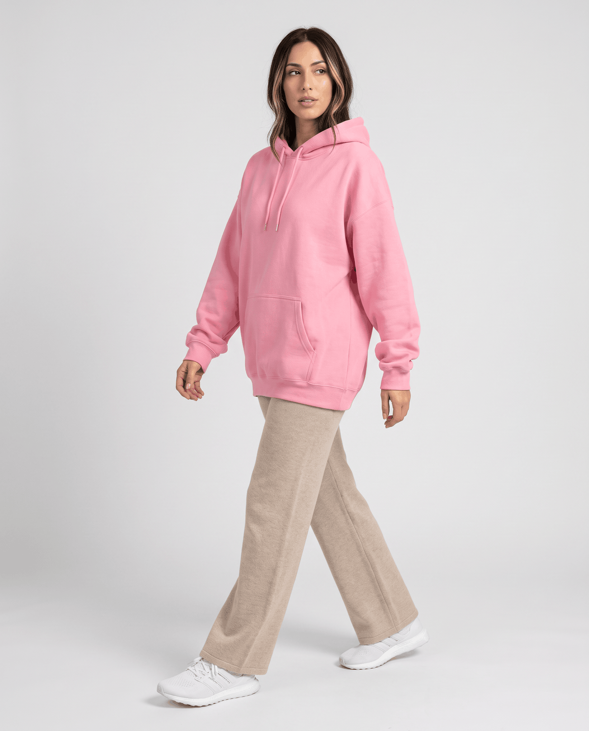 Full-length walking look pairing the pink hoodie with khaki wide-leg pants and white sneakers