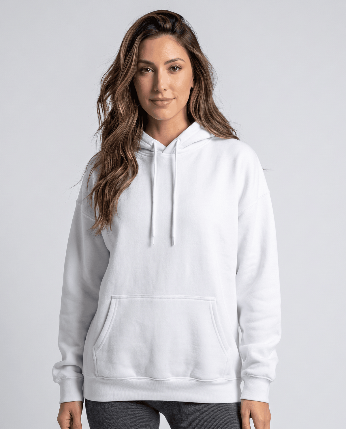 White pullover hoodie with drawstring hood and front pocket worn with dark pants, front view