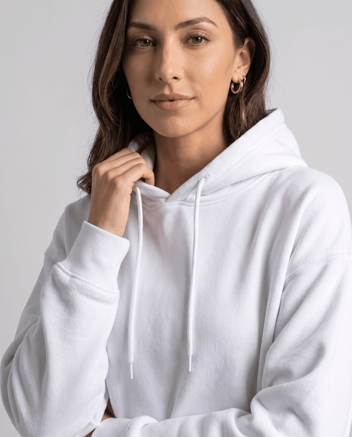 White hoodie close-up showing the drawstring hood and long sleeve