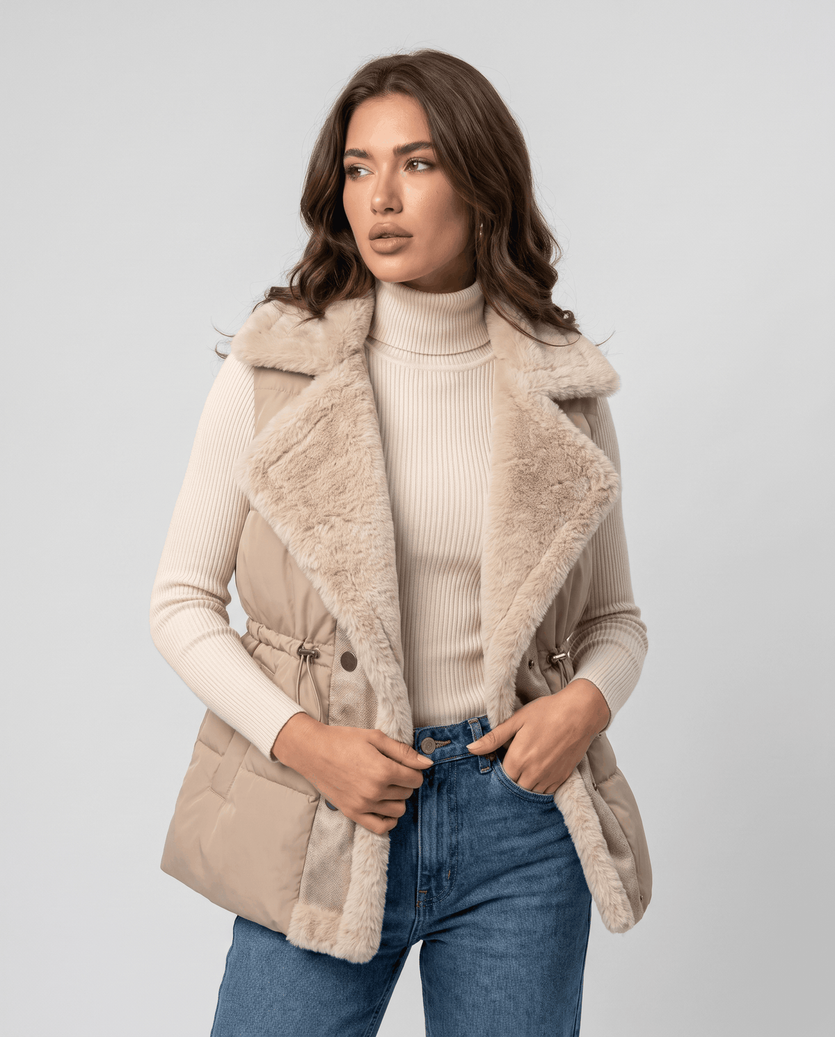 Brown padded vest with plush collar and button front worn over a cream knit