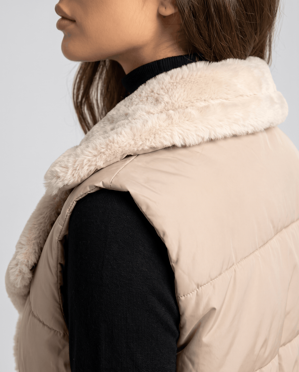 Side view of brown padded vest plush collar and sleeveless armhole