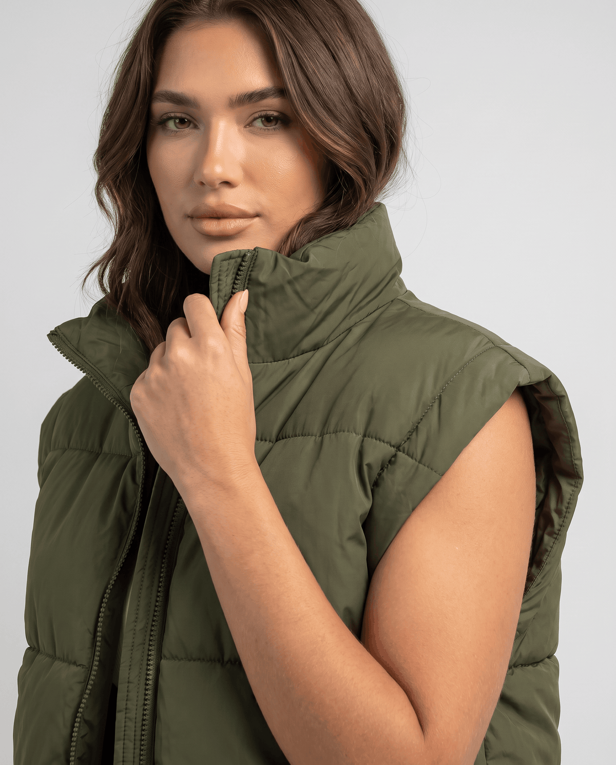Green padded vest stand collar and zip shown up close on a model