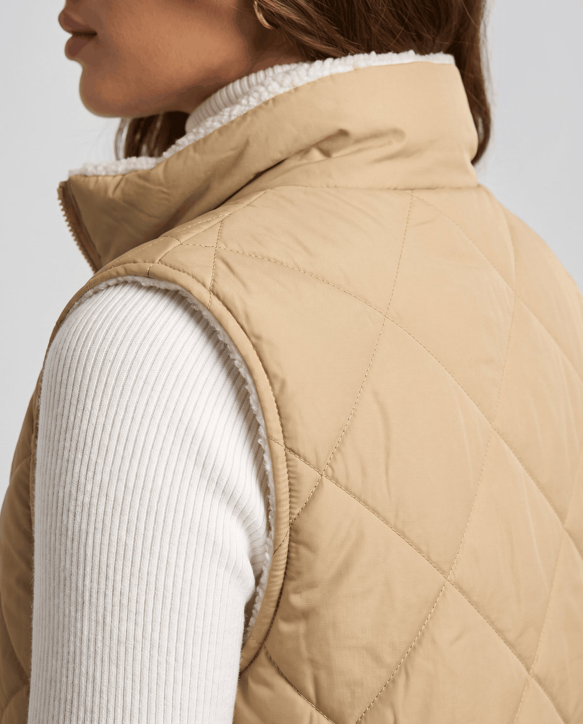 Close side view of khaki quilted vest collar and diamond stitching