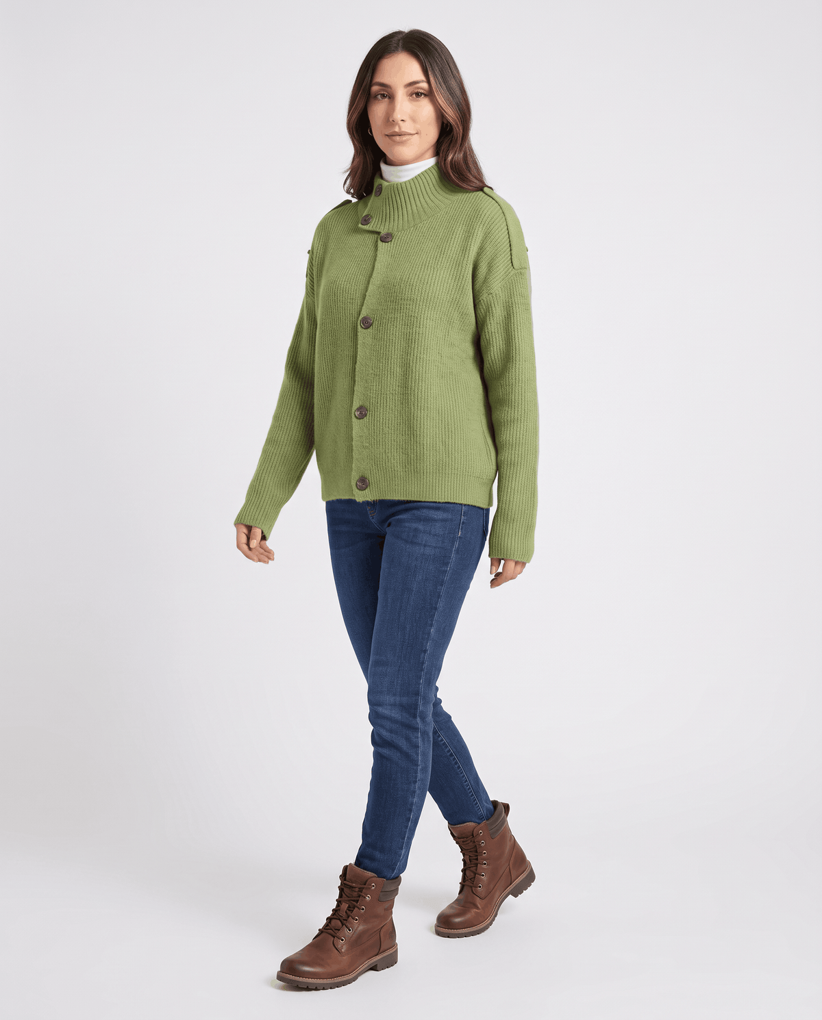 Woman in green button-front ribbed cardigan styled with dark jeans and brown boots