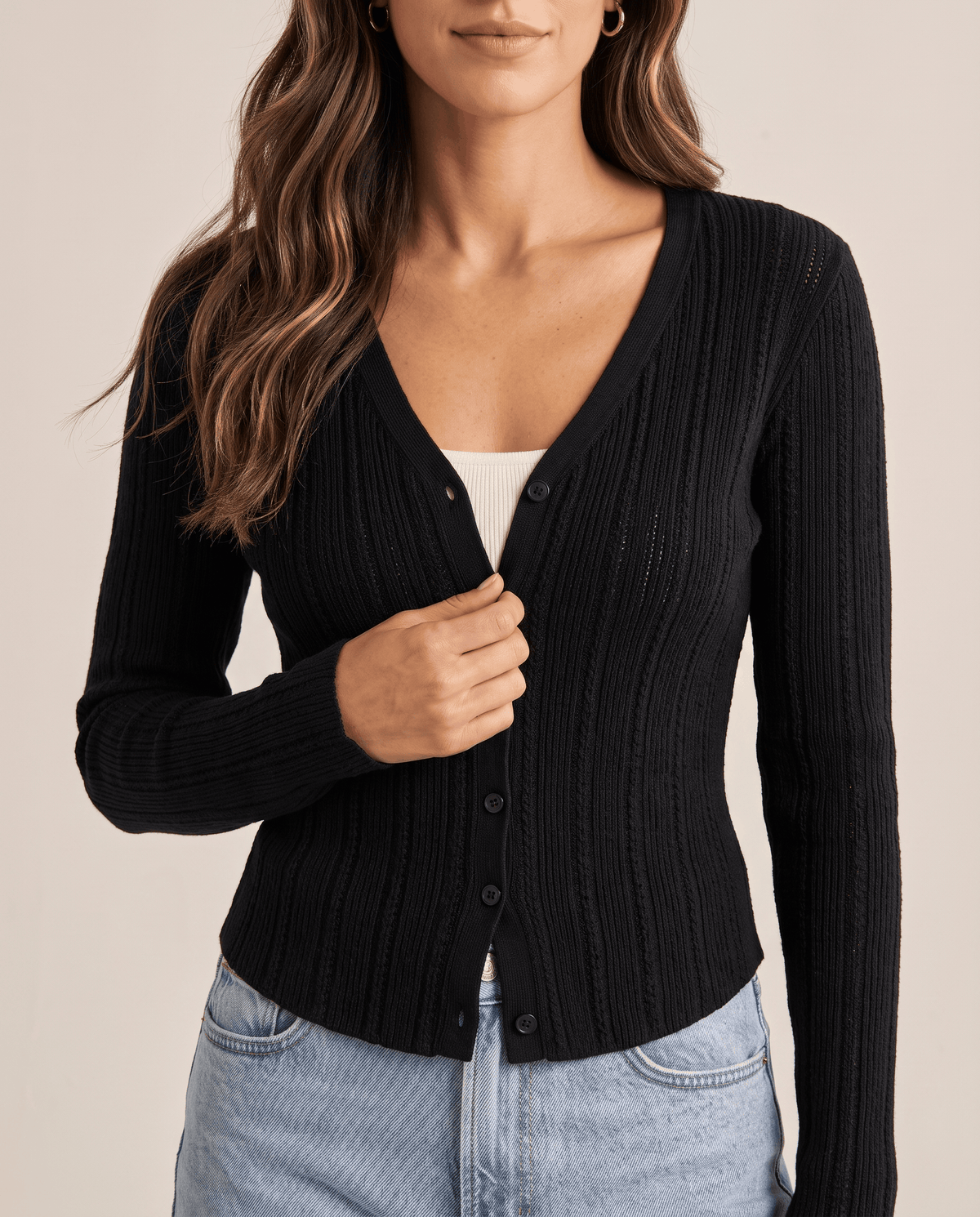 Close view of black ribbed cardigan V neckline and button front