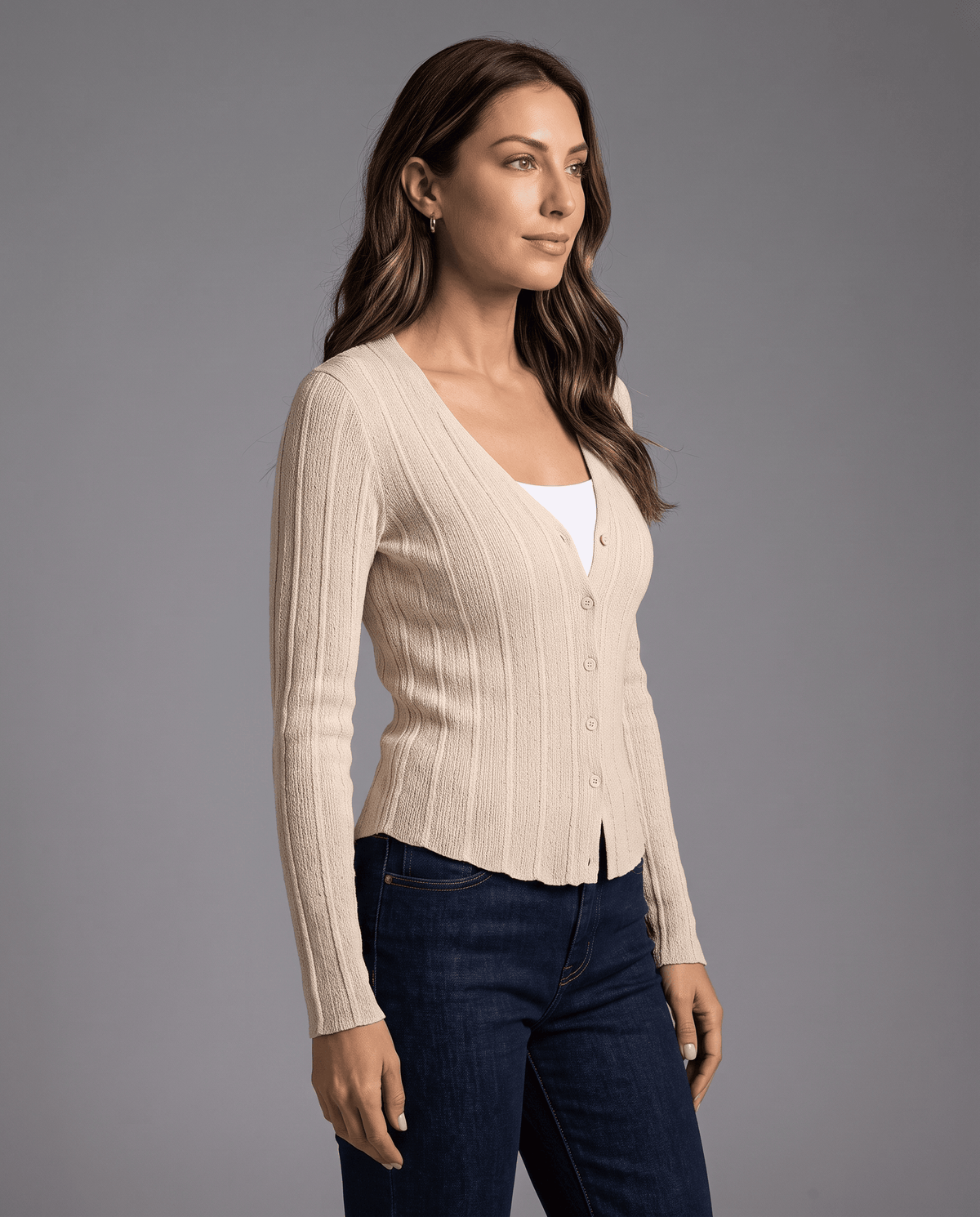 Side view of cream ribbed button-front cardigan worn with dark jeans