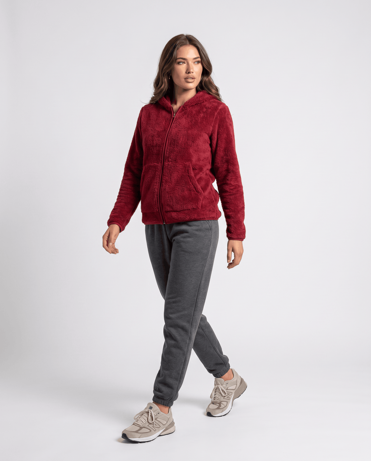 Full-length burgundy sherpa hoodie styled with gray joggers and sneakers