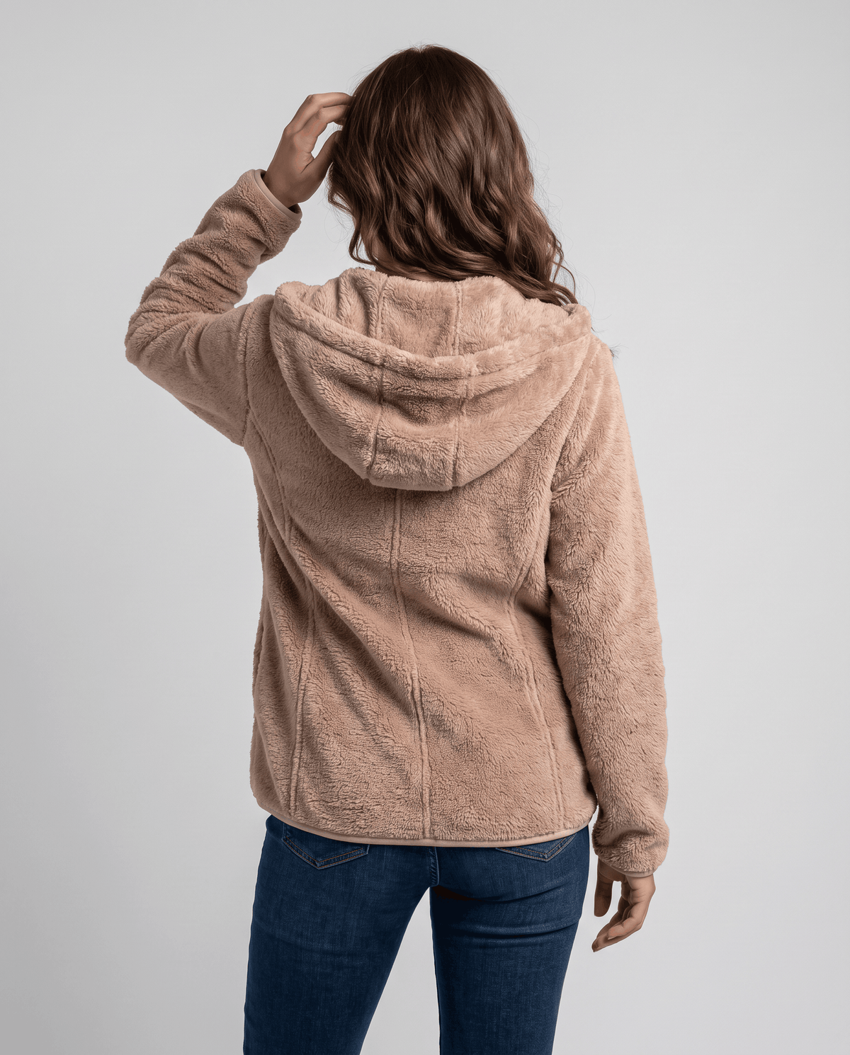 Back of tan sherpa hoodie with a hand on the hood and jeans