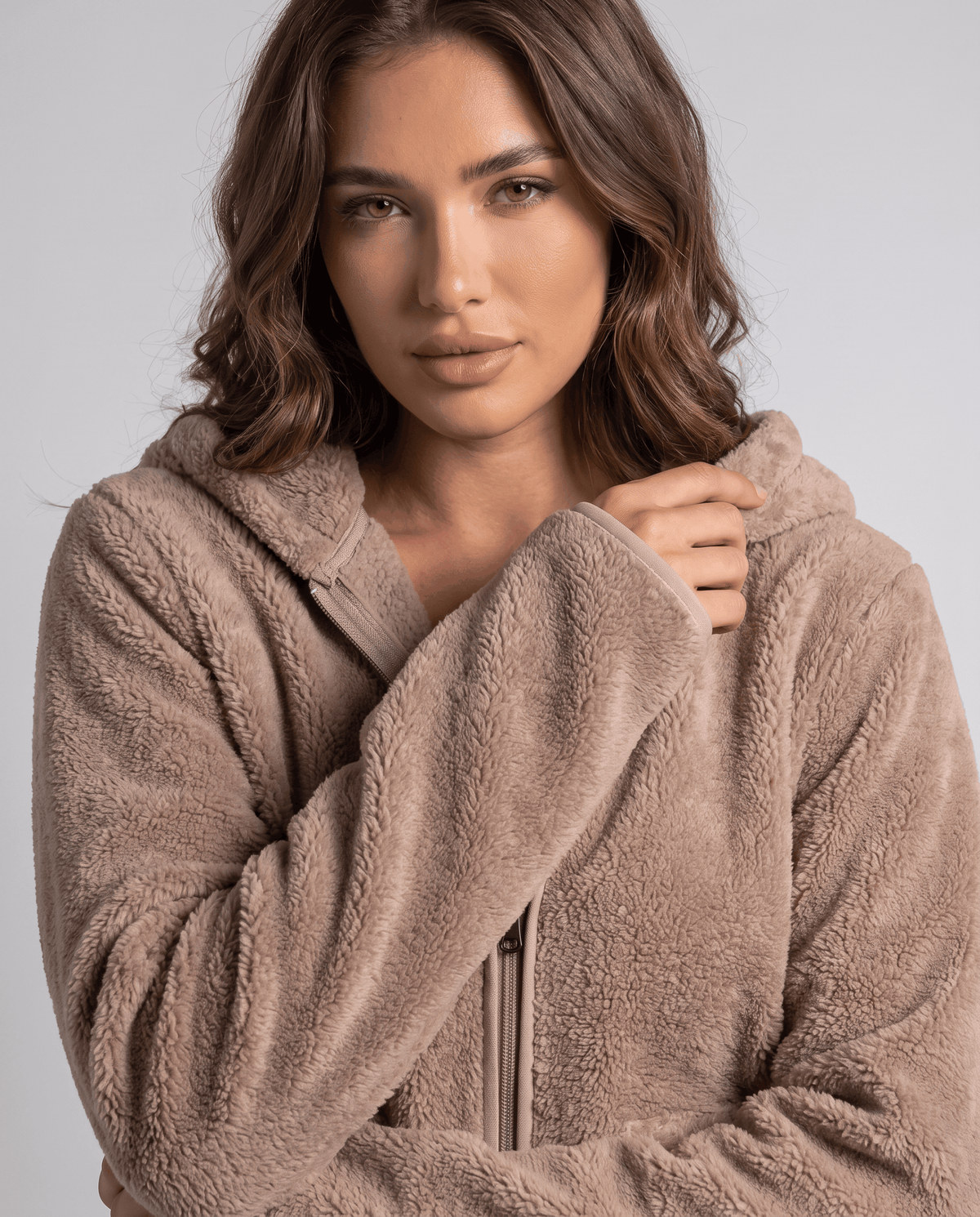 Close-up of tan sherpa hoodie zip and collar with soft fuzzy texture