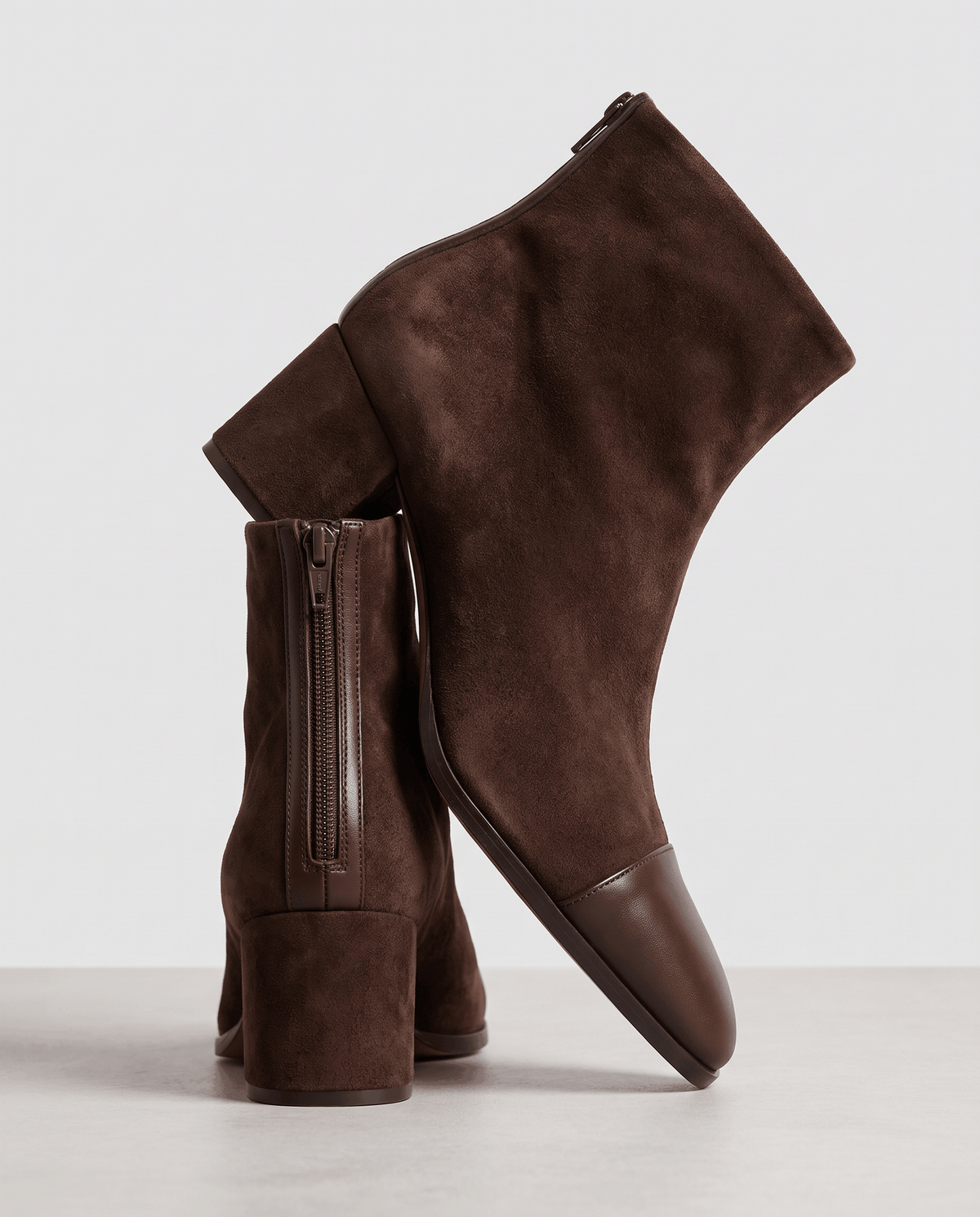 Brown suede ankle boots stacked to show the heel and toe