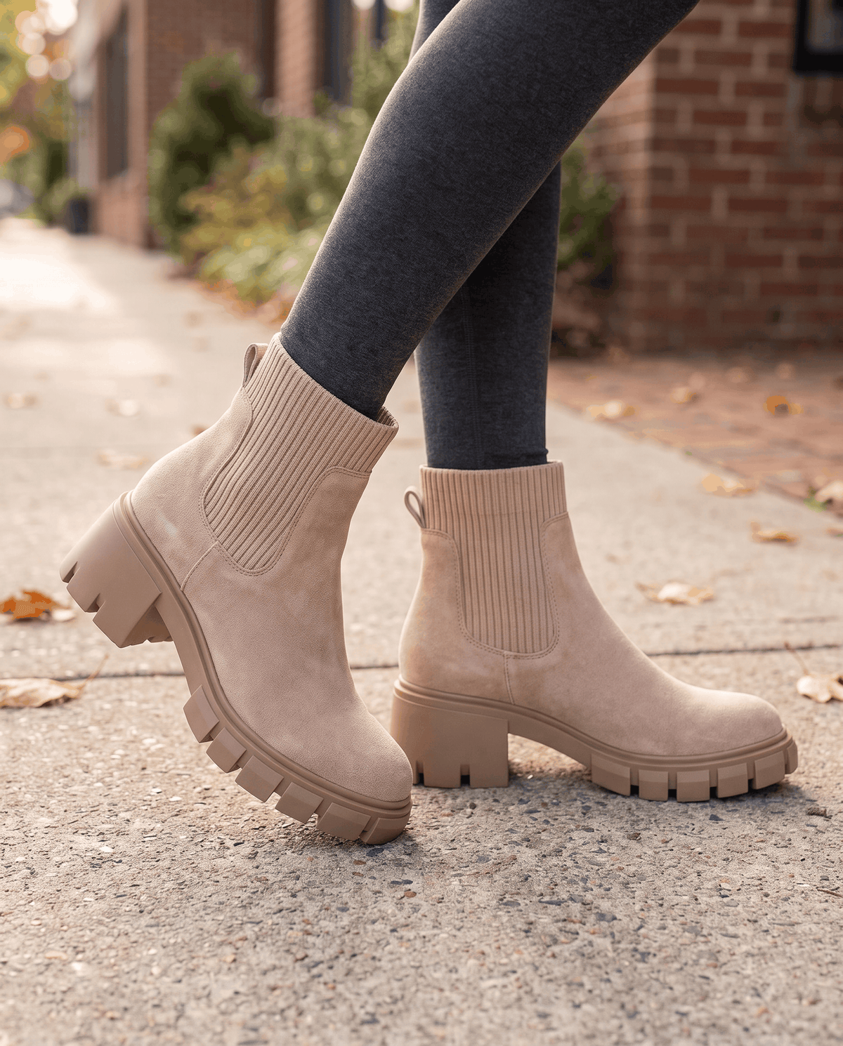 Apricot suede platform boots worn with dark leggings on a street