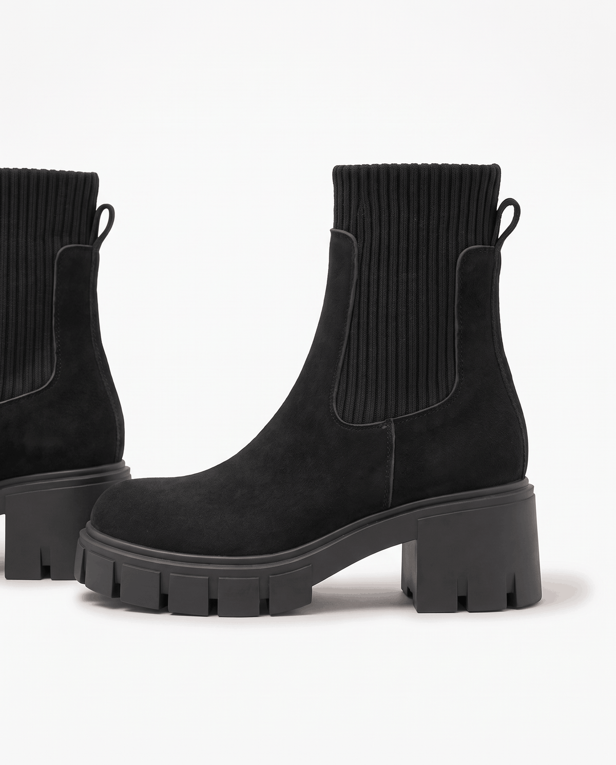 Black suede platform boots angled to show heel and sole depth